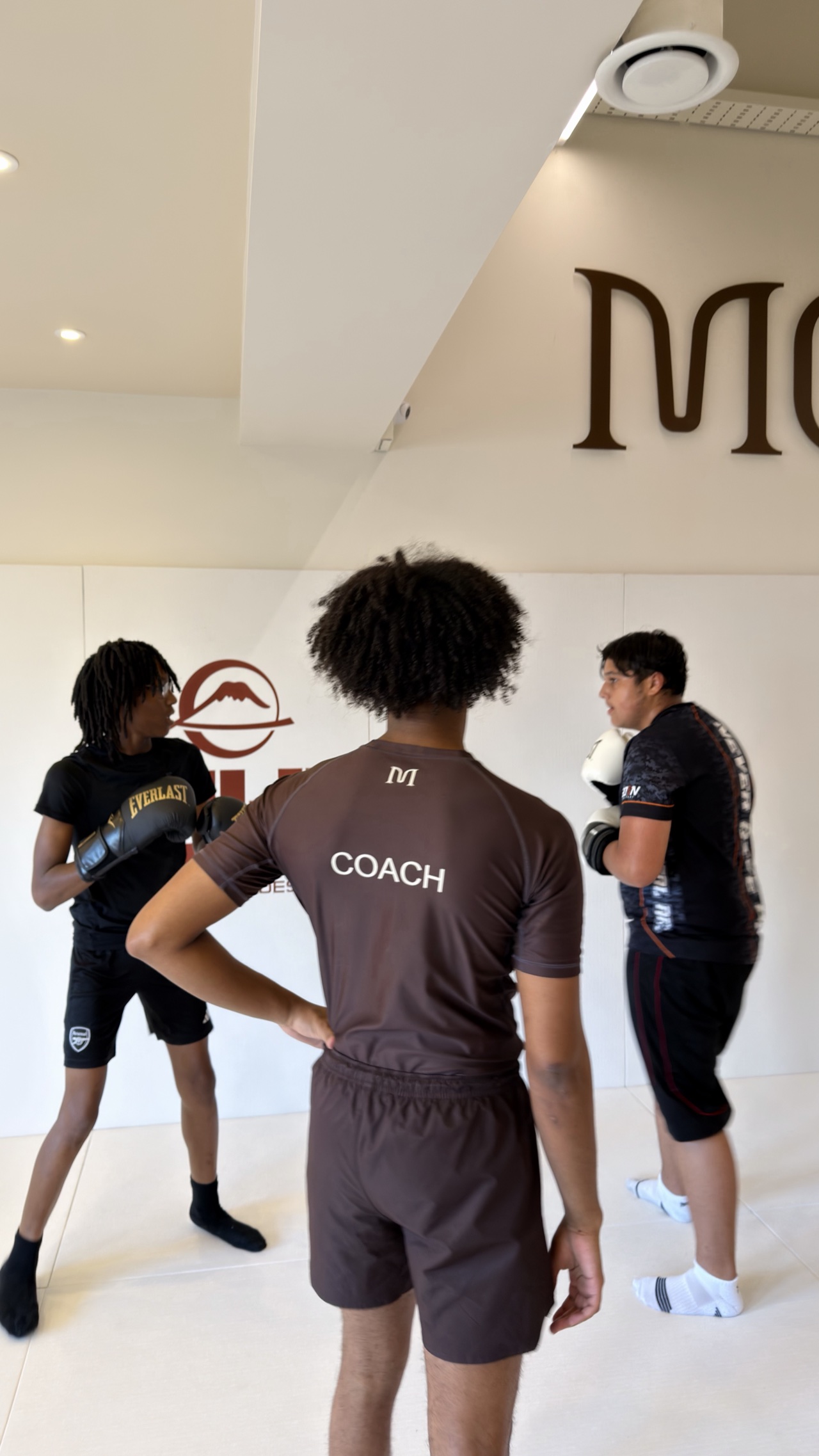 A beginner grappling with a coach on the mat at MOGA
